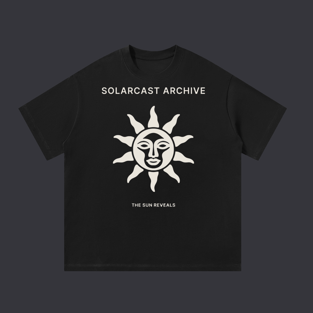 The Sun Reveals tee: a bone print on the front showing a sun with a face and rays above the words The Sun Reveals, on a black cotton tee.